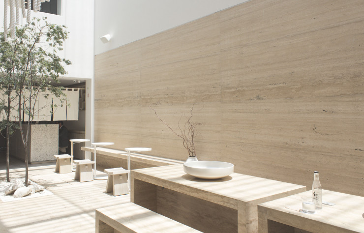 Dans le patio, le travertin passe des murs au mobilier.