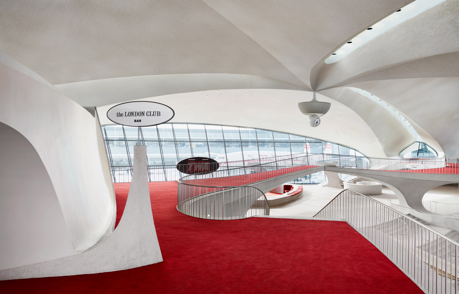 Le « London Club » surplombe la piste et le Flight Bridge qui traverse tout le hall...