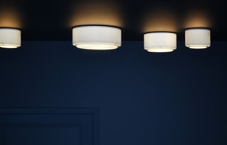 Le plafonnier « G13 » est composé d’une grille en métal perforé et d’un dispositif en verre, au sein duquel se diffuse la lumière (Sammode).