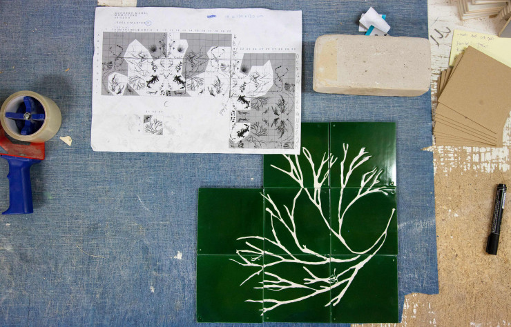 Issus de l’herbier des Glithero, les motifs des « Botanical Tiles » sont transposés sur ordinateur, puis esquissés en poudre de craie sur un voile appliqué sur les carreaux qui sert de guide aux artisans, « griffant » la surface pour faire apparaître le motif.