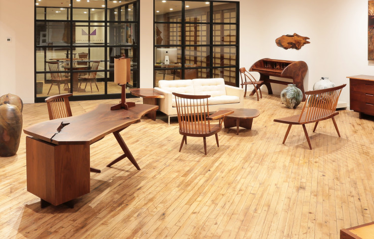 Au premier plan, bureau « Conoid » en noyer américain de George Nakashima.
