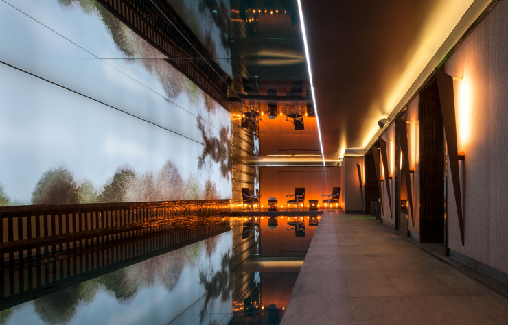 Au spas Nolinski by La Colline, murmure transparent de l’eau, sol minéral en granit, boiseries chaudes et flammes de bougie participent d’un bien-être tamisé.