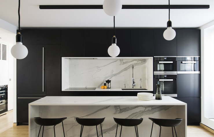 La cuisine se détache du reste de la pièce à vivre grâce à la profondeur de son cadre noir.