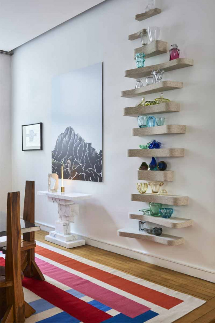 Sur des étagères habillées de feutre d’Hubert de Malherbe, une collection de verreries de Murano. À gauche, sur la console Kasimir en marbre de Calacatta d’Hervé Van der Straeten, sculpture chinée aux puces. Au-dessus, photo d’une installation de land art (création Hubert de Malherbe).