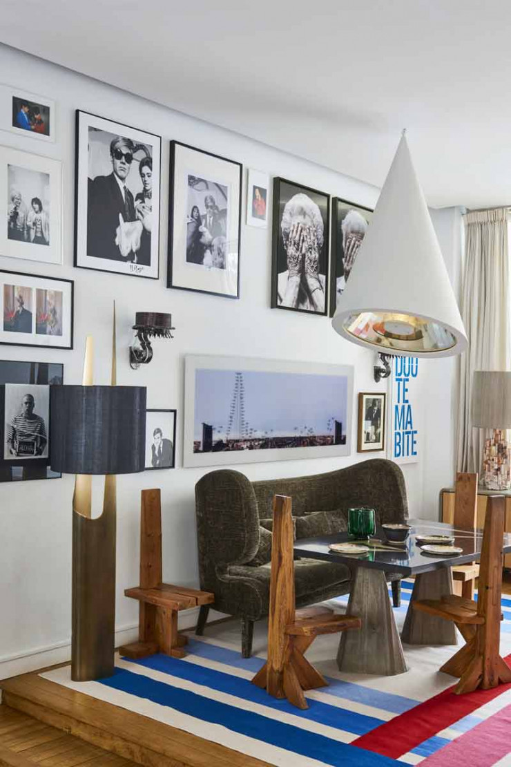 Dans le salon, autour de la table haute avec pieds en béton et plateau en ébène (Malherbe Edition), quatre chaises en chêne de Dominique Zimbacca (1970, Galerie Yves Gastou). Contre le mur, canapé Éléphant, design Jérôme Faillant-Dumas et Gaëtan Lebegue (The Invisible Collection). À gauche, lampadaire R12, design Thierry Lemaire (The Invisible Collection). Tapis kilim en laine Codimat Collection. Suspension réalisée à partir d’une lampe de dentiste détournée, une création d’Hubert de Malherbe. Au-dessus du canapé, photo de Renaud Auguste-Dormeuil (galerie In Situ).