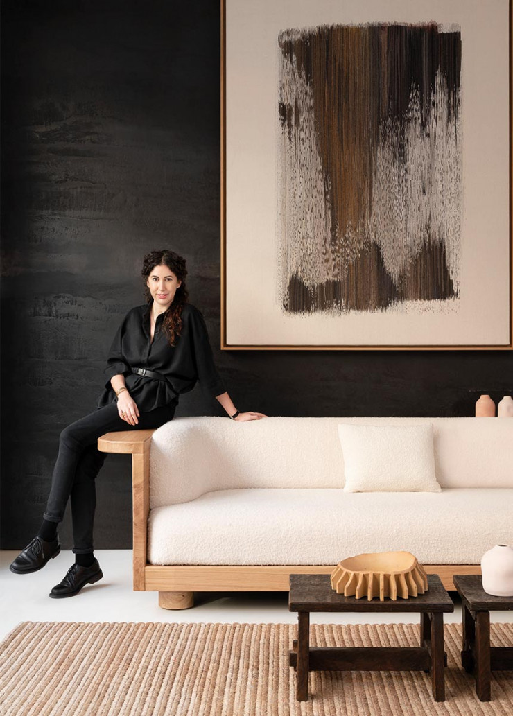 Emmanuelle Simon, assise sur la structure en chêne massif brossé du canapé Nativ, qu’elle a dessiné pour la galerie JAG (Paris VIIe).