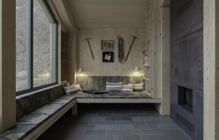 Avec 4,60 mètres de hauteur sous plafond et des ouvertures panoramiques, la cabine principale se veut aussi lumineuse que cosy, grâce aux généreuses banquettes qui cadrent la cheminée.
