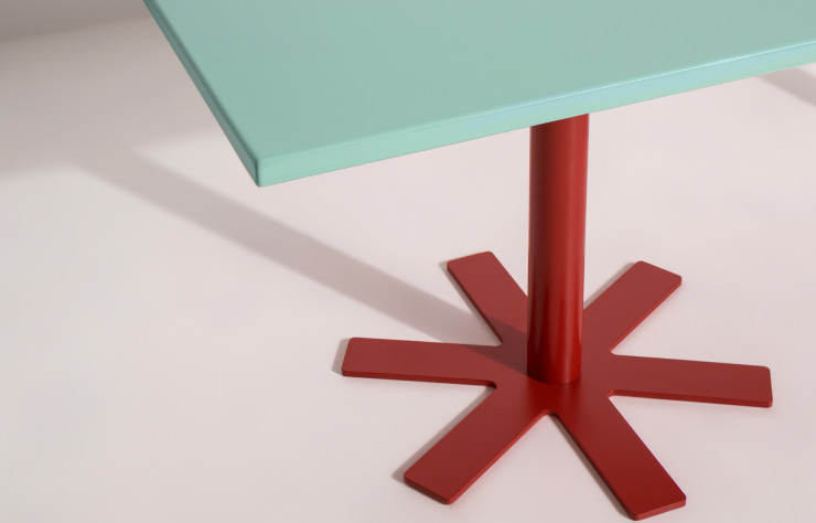 Le plateau émaillé de la table Parrot, d’India Mahdavi, contraste avec son pied rouge-orangé, évoquant un perroquet.