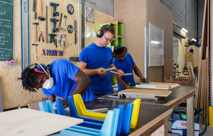 Des artisans en insertion lors de la conception du meuble Henri en aggloméré recyclé.