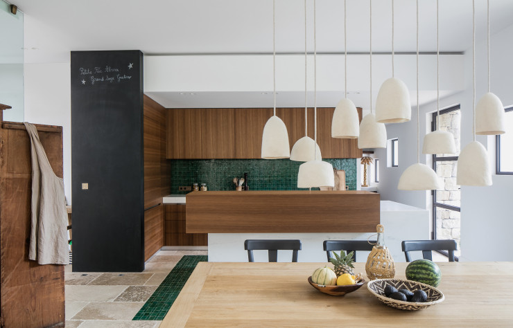 Réalisée par Caprini & Pellerin, cette cuisine contemporaine sur mesure laisse les matières naturelles s’exprimer : chêne de fil brossé sur les façades, marbre de Carrare pour le plan de travail, zelliges verts en crédence et en tapis de sol. Robinetterie Watermark, électroménager Gaggenau.