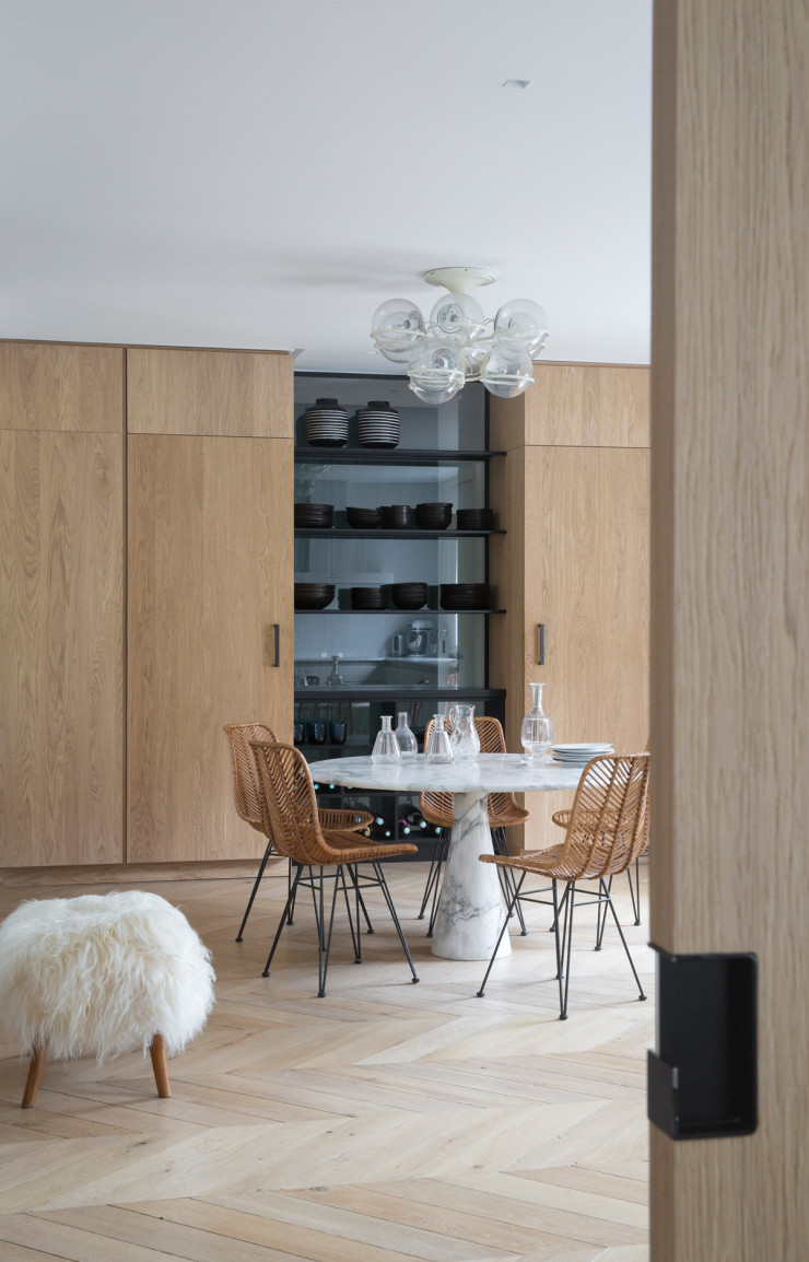 Ici, elle a aménagé la cuisine comme un espace central où se retrouver. Les portes en chêne dissimulent électroménager et rangement, et un vaisselier vient briser le rythme.