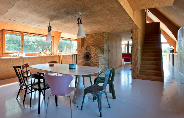 Dans la cuisine, tous au poêle ! D’origine et tout en brique, il réchauffe et fait aussi office de four à bois. La ronde des chaises autour de la table Pion, que Ionna Vautrin a conçue pour l’éditeur espagnol Sancal, peut animer une conversation entre fans de design : chaise rose 3107 (au fond), d’Arne Jacobsen (Fritz Hansen), chaise A en acier brut (au fond), de Xavier Pauchard (Tolix), chaise rouge Basel (au premier plan), de Jasper Morrison (Vitra), fauteuil empilable Pipe (au premier plan, à gauche), de Jasper Morrison (Magis)… Sur la table, un cendrier rouge Clam, d’Alan Fletcher (Mebel Italy), de 1968, et un vase bleu Fischietto d’Ettore Sottsass (Habitat). Si Ionna Vautrin n’avait pas son CAP cuisine, elle pourrait passer haut la main son diplôme d’architecte d’intérieur !
