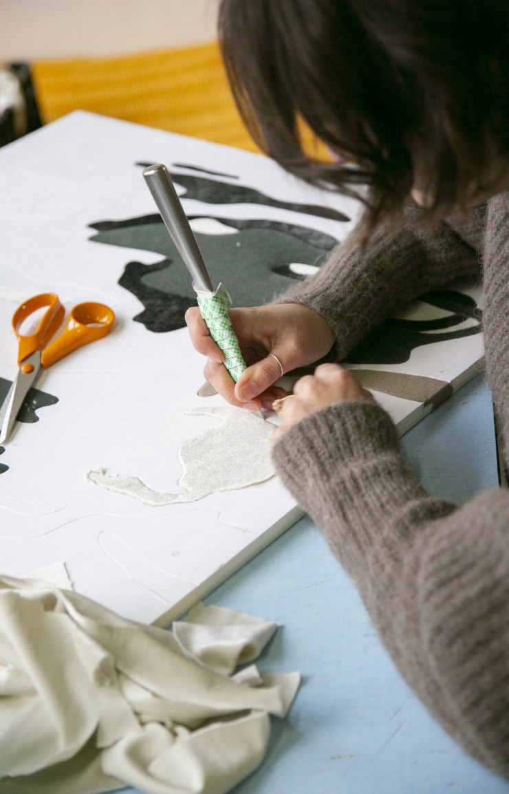 L’artiste découpe et assemble des morceaux de velours.