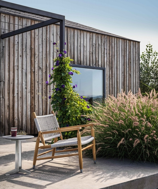 La structure du fauteuil Tessa Outdoor de Flexform est entièrement réalisée en iroko massif et son tressage en polypropylène pour plus de résistance aux éléments.