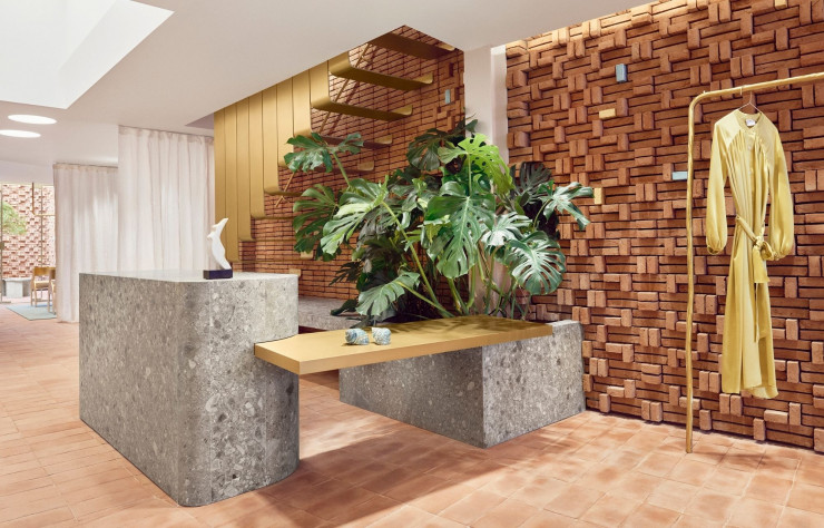 La pierre grise de ceppo lombardo a été utilisée pour créer un comptoir de service massif et la base de jardinières remplies de verdure. Un bloc d’onyx jaune pâle forme également la première marche de l’escalier.
