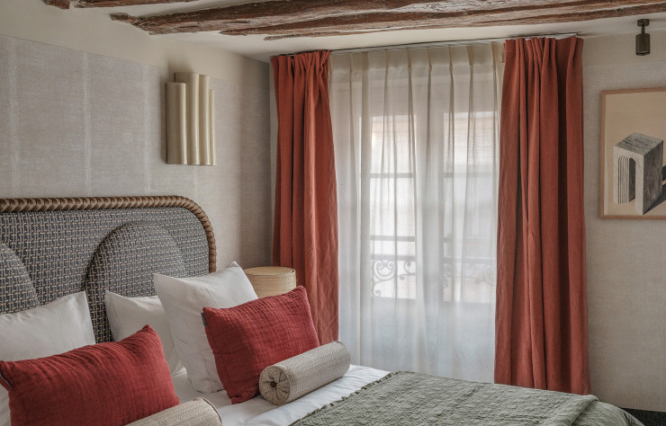 Coiffée de poutres, cette chambre incarne à merveille l’esprit maison de campagne.