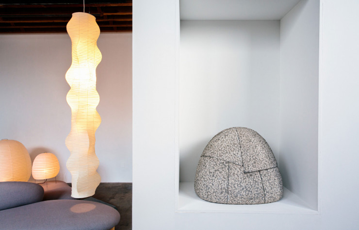 Installation de l’exposition « Objects of Common Interest: Hard, Soft, and All Lit Up with Nowhere to Go » au Noguchi Museum jusqu’au 13 février 2022. Sofa et Ottoman de forme libre dessiné par Isamu Noguchi pour Herman Miller en 1948 et réédité par Vitra depuis 2002. Luminaires en papier, bambou et métal Akari B (1954), Akari 20N (1968) et Akari 21N (1954). À droite, « Young Moutain » en granit Aji (1970)