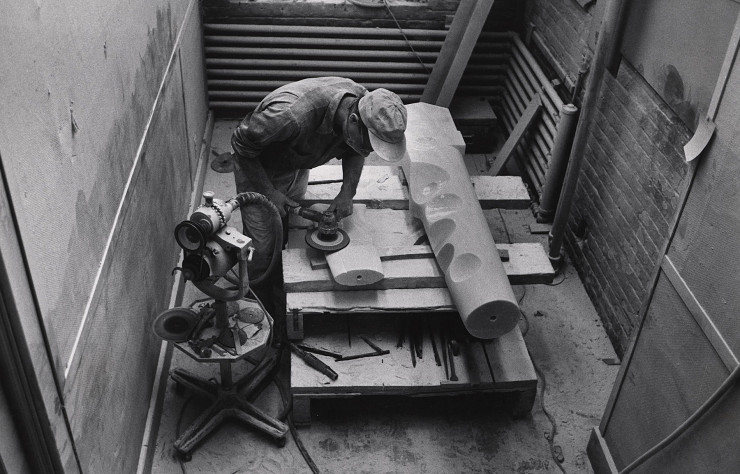 Isamu Noguchi en train de travailler sur sa « Figure Portion of Composition for Arrivals Building » en marbre grec pour l’aéroport d’Idlewild en 1958. Archives du Noguchi Museum.