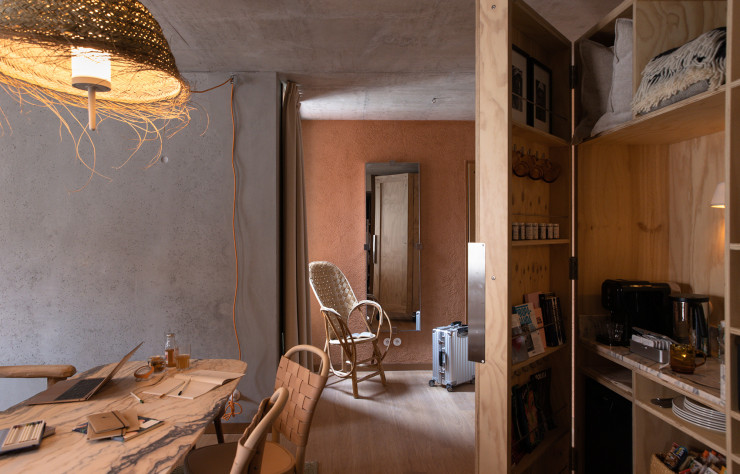 Sur les murs, un enduit d’argile granuleux remplace la traditionnelle peinture. A droite de l’image : le bar fait sur-mesure.