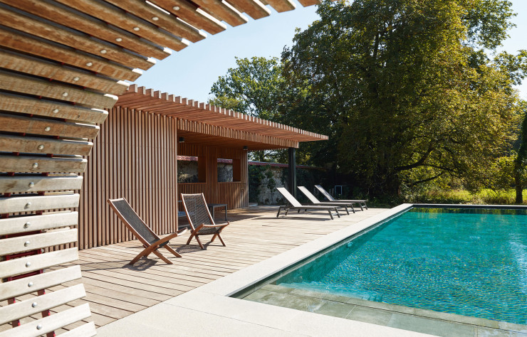 L’environnement en bois de ce bassin, sans chercher à se fondre dans le paysage, s’y inscrit avec harmonie. La piscine semi-enterrée carrelée contribue au cachet stylisé de cet extérieur. (Carré Bleu Lubin Piscines à Orléans (45). Architecte : Ingrid Taillandier – ITAR Architectures à Paris 3e)