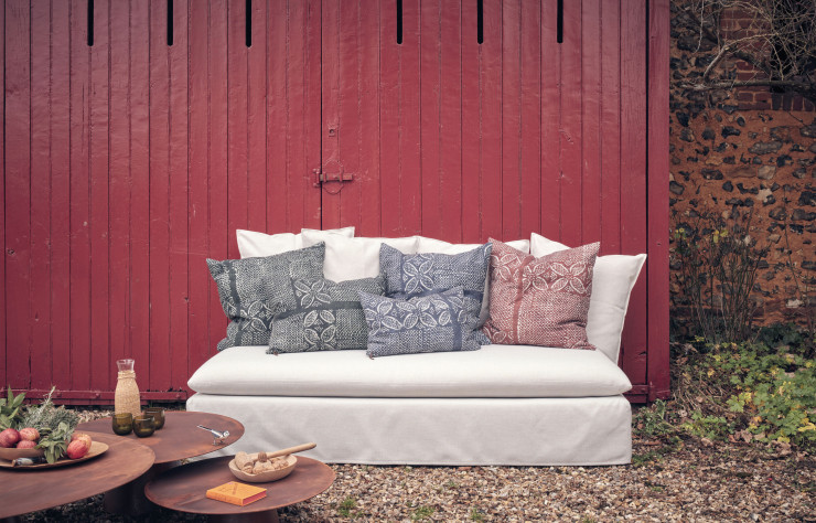 Dans la collection « Gypset », de Maison de Vacances, banquette en toile Riva Off White, coussins en tissu Bogolan et tables basses de la collection « Beside » en acier oxydé wabi sabi.