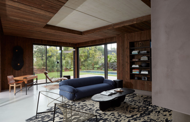 Dans le coin salon, le bardage extérieur en bois se prolonge à l’intérieur pour offrir une continuité dedans-dehors.