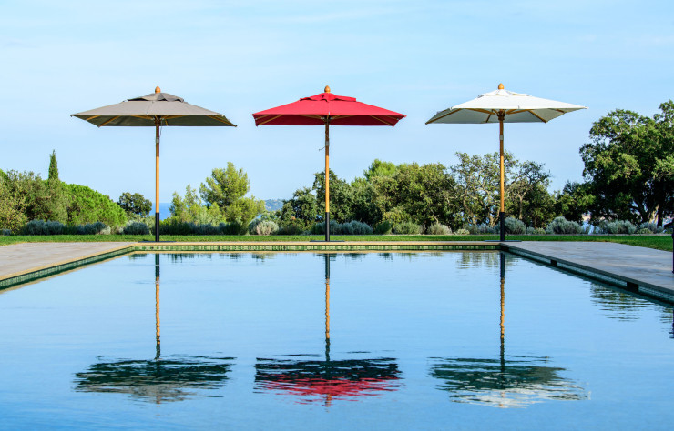 La gamme de parasols « Roma » : 12 dimensions, 12 couleurs, un mât ultra-robuste et des fourchettes taillées à la main.