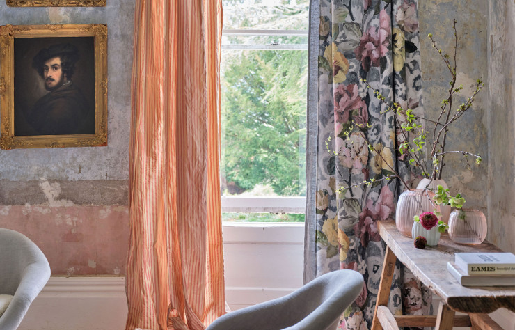 À droite, Tapestry Flower Platinum est un motif très pictural de roses et de pivoines sur un fond damassé contemporain abstrait. Imprimé par procédé numérique sur du lin, il est certifié Oeko-Tex. À gauche, tissu à rayures Calozzo Stripes en taffetas. Pour un effet irisé et vibrant sur des rideaux, des coussins ou des stores sophistiqués. Ce modèle est également lavable et disponible en Trevira CS pour des commandes spéciales.