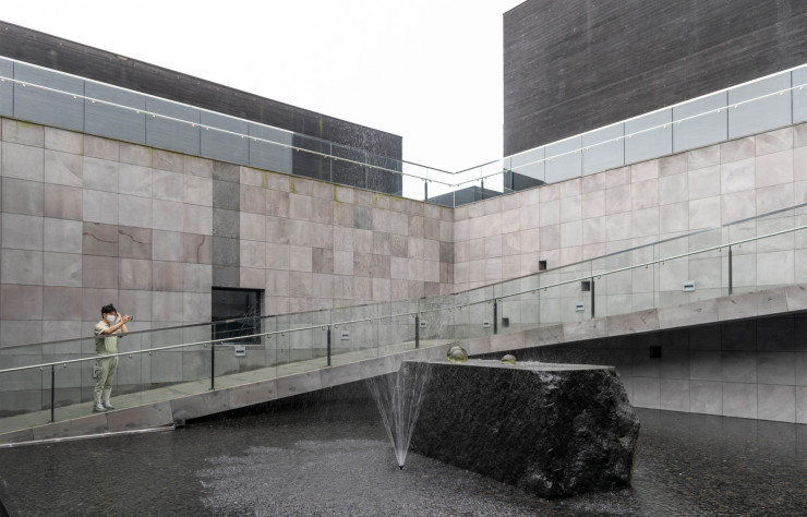 Comme des larmes, des boules de cristal de diseuse de bonne aventure, des gouttes de pluie… le plasticien Kim Tschang-yeul (1929-2021) a sculpté des sphères de verre et en a même orné ses tableaux. Le musée monographique qui lui est consacré, conçu par l’agence séoulite ArchiPlan, répond élégamment au travail de l’artiste par l’entremise d’un patio aquatique, de meurtrières de lumière et de matières noires.