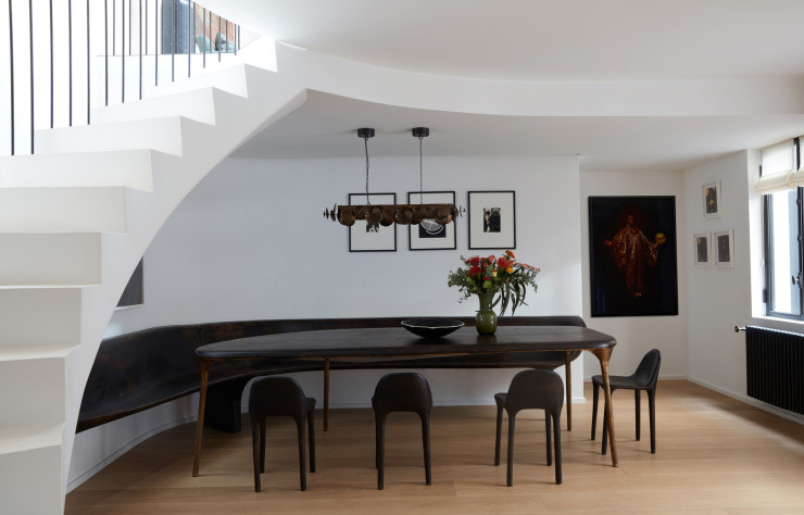 Dans la salle à manger, table, chaises et banquette en chêne brûlé et laiton signées Valentin Loellmann (Galerie Gosserez). Suspension Eucalyptus (Ochre). Plafonnier Candela di Vals de Peter Zumthor (Viabizzuno). Au mur, photos d’Omar Victor Diop.