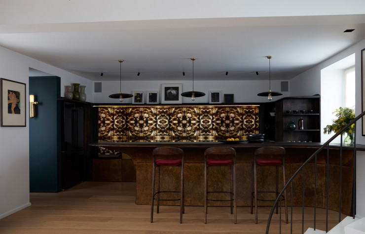 Devant le bar, tabourets hauts Neva Light (Artisan). En haut à gauche, vases italiens en opaline Marie Ducasse Design. Sur le mur de gauche, peinture de Man Ray et applique ISP Wall d’Ilia Potemine (DCW Editions). La crédence de la cuisine est une pièce unique réalisée à partir de photos imprimées sur métal de Mathilde de l’Ecotais. En hauteur, tableaux de Lina Iris Viktor et Peter Blake.
