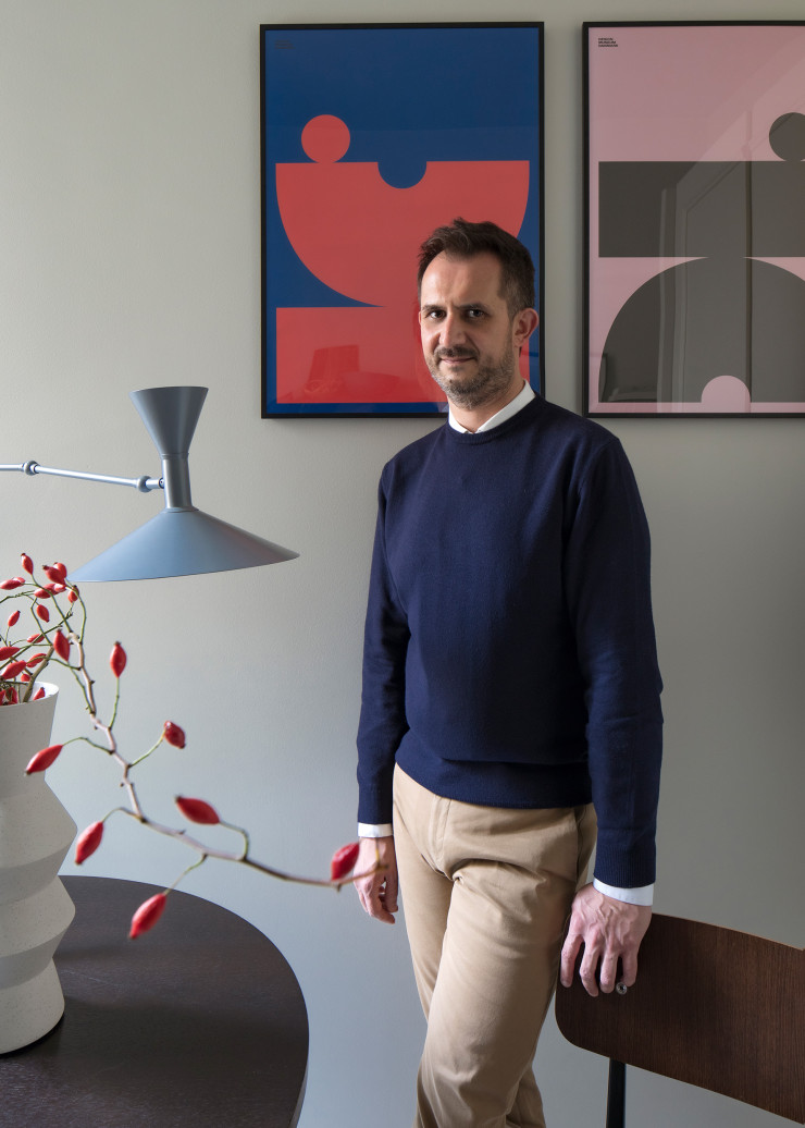 L’architecte Andrea Rubini dans la cuisine de son propre deux-pièces milanais, éclairée par La Lampe de Marseille de Le Corbusier.