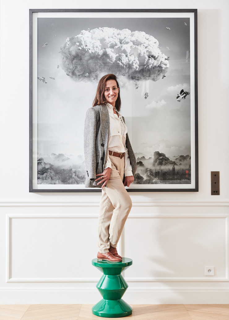 L’architecte d’intérieur Alexandra Boussagol, perchée sur le tabouret Zig Zag (Pols Potten), devant une œuvre signée Yang Yongliang.