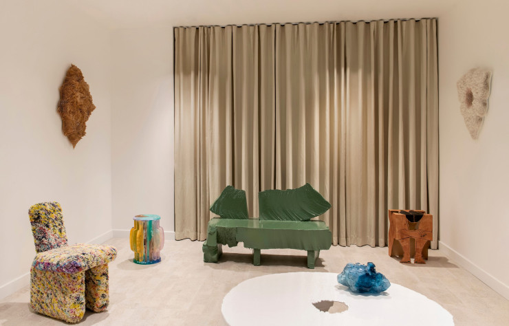 Entre l’assise Tufted Pillow et le banc Poly signés Max Lamb, table d’appoint Una Historia Filosófica de los Jardines I, de Jie Wu. À droite, tabouret American Dream de Saelia Aparicio. Au premier plan, création Architectural Glass Fantasies de Stine Bidstrup. Sur les murs, deux pièces délicates de Rowan Mersh.