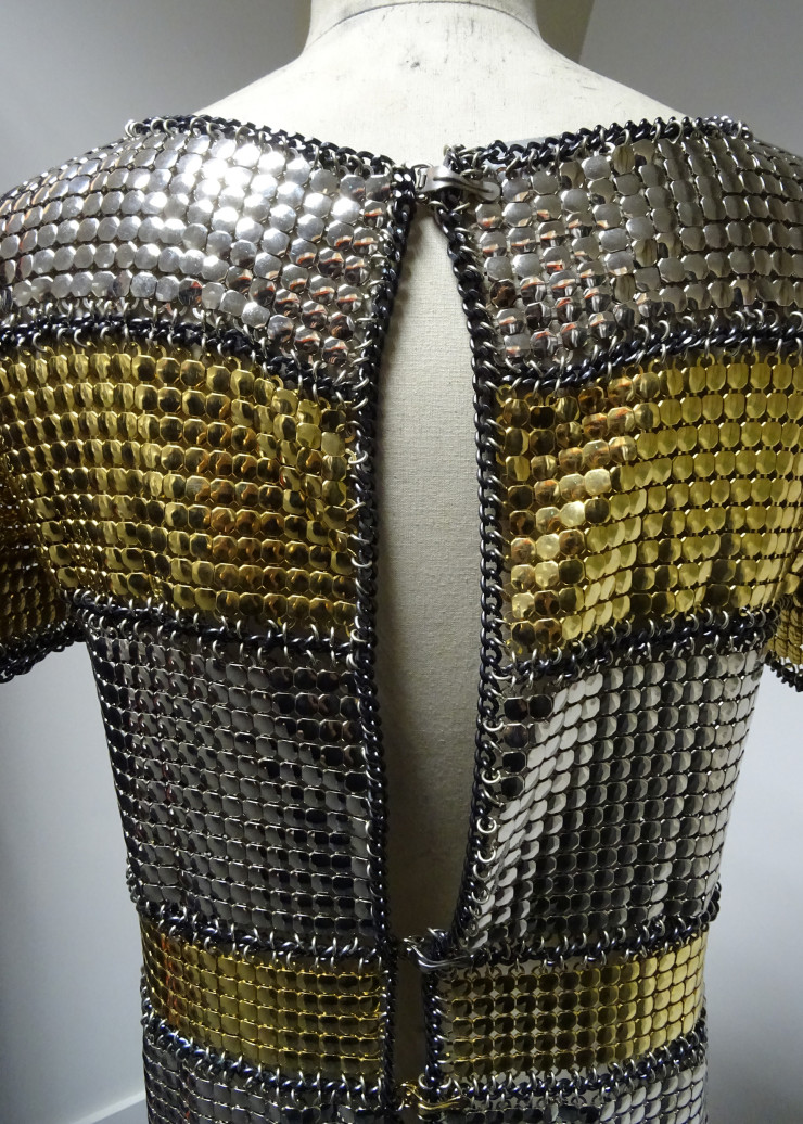 Mini-robe de la collection « Haute couture printemps-été 1967 ». Cotte de mailles dite « squam » en acier chromé et doré, chaînes d’acier noires et anneaux métalliques argentés.