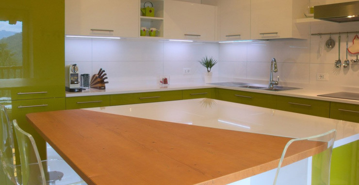 Cuisine au couleur vert olive brillant, adouci par les espaces blanc de lait et les plans de travail en quartz, où le blanc est refroidi par une pointe de gris – Marazzi