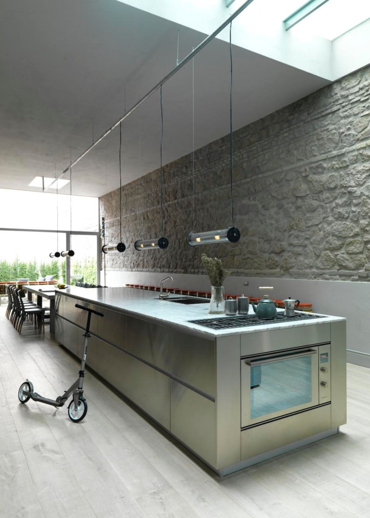 Ce grand espace ouvert a nécessité un ameublement surdimensionné. Table à manger de 4 m de long conçue par le studio Emporio.Autour, 12 chaises Czech de Hermann Czech (Gebrüder Thonet). Îlot de cuisine Pedini long de près de 5 m. Cuisinière Barazza.Réfrigérateurs Smeg. Suspensions In The Tube de Dominique Perrault et Gaëlle Lauriot‑Prévost (DCW Éditions). Carlo a emprunté à son ami, l’artiste Benedetto Marcucci, une oeuvre déjà exposée à New York, à Rome et lors de la Biennale de Venise.
