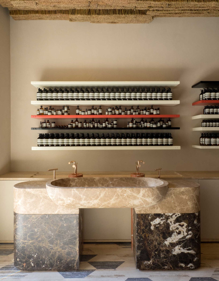 Pour la boutique romaine Aesop, le studio Luca Guadagnino a utilisé de la pierre texturée, du marbre rose et des bottes de paille. Une manière de faire visuellement écho aux anciens bâtiments de la ville.