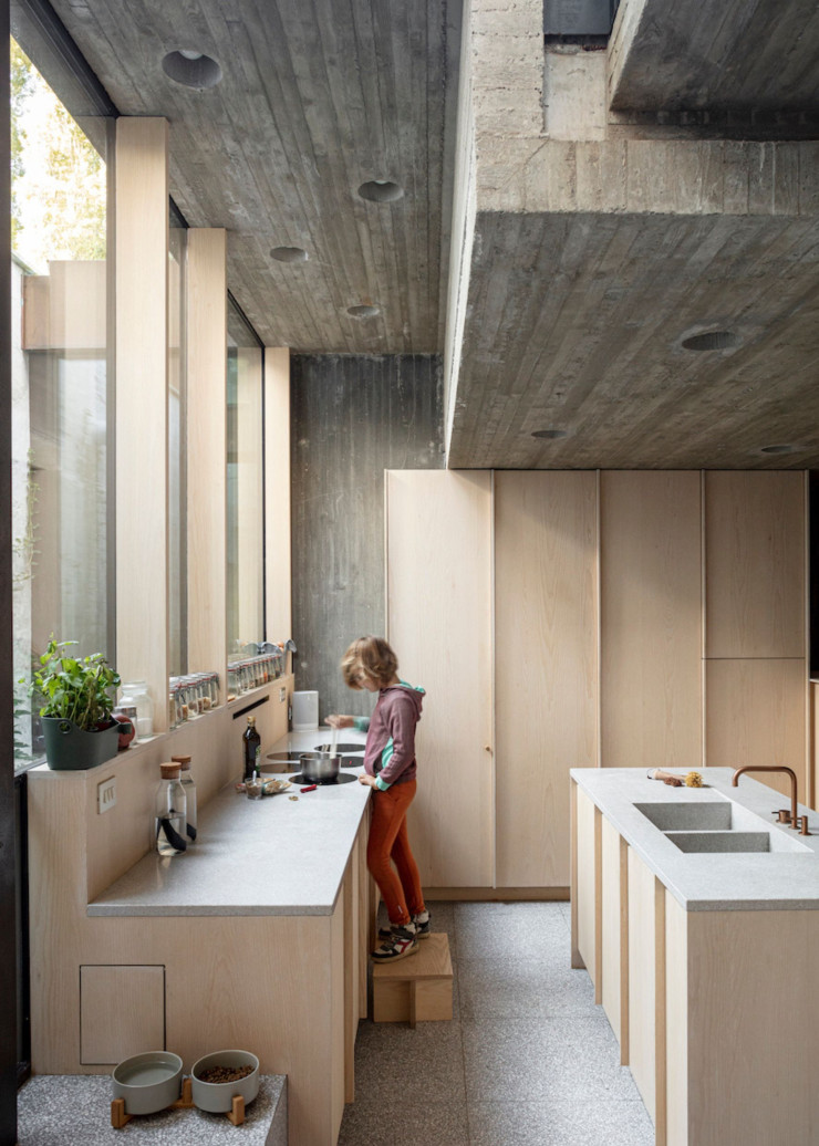 La cuisine aussi offre un rythme très dynamique sur le plan des matériaux. Le moule du plafond en béton a été réalisé avec des planches de 5 cm, permettant des textures très organiques. Là encore, les portes de placards font écho au dessin de la façade.