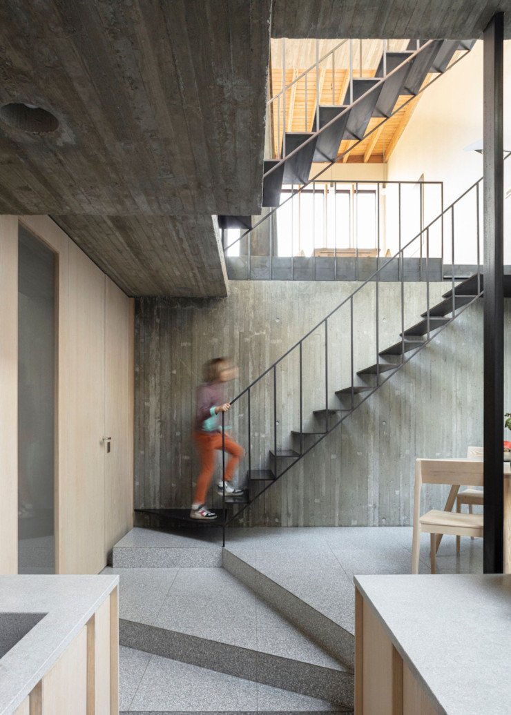 Bien que la cuisine soit située à un niveau inférieur et plus enterrée, elle n’est en rien étouffante et communique visuellement avec l’espace de vie grâce à l’escalier très ouvert.
