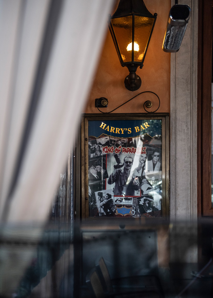 La photo de Rino Barillari, « le Roi des Paparazzi », est affichée dans la vitrine du légendaire Harry’s Bar. Le photographe a capté les turbulences de la Via Veneto à la grande époque de La Dolce Vita (1960), de Fellini – et encore bien après.