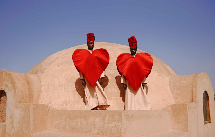 To the Moon and Back #2  mêle l’architecture et les apparats typique du pays d’origine de Mous Lamrabat à ces grands coeurs de soie rouge, symboles d’amour et d’union entre les deux cultures que le photographe partage.