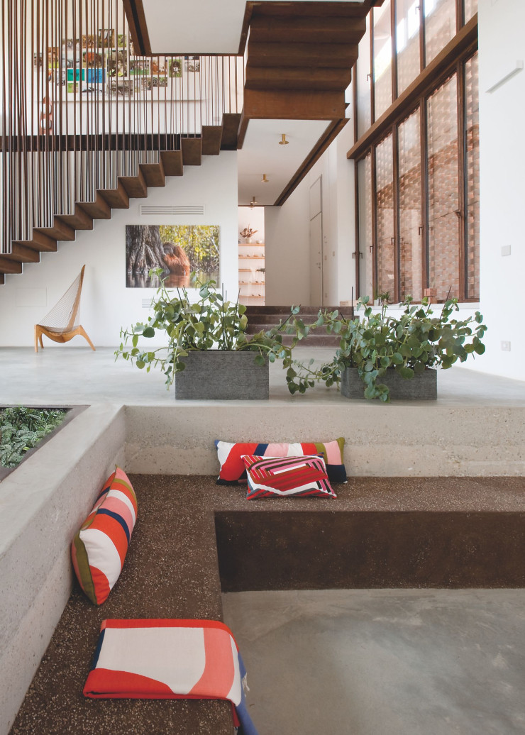 Sous le bel escalier intérieur en acier Corten, le siège Harp de 1968, design Jørgen Høvelskov (Christensen & Larsen). Éclairages Candela di Vals, design Peter Zumthor (Viabizzuno). Coussins Mapoesie.