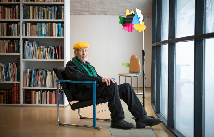 Yrjö Kukkapuro pose près de son célèbre luminaire Perhonen.