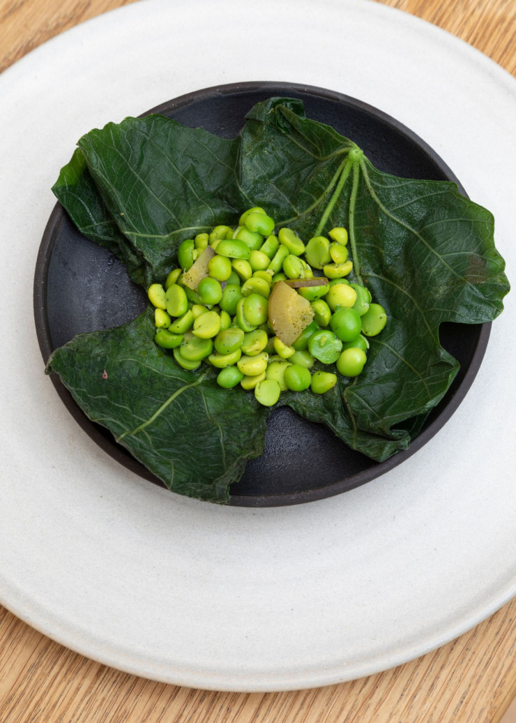Chez Kadeau, à Copenhague, petits pois servis dans des feuilles de figue grillées sur le feu de bois pour réchauffer doucement les pois et libérer les arômes des feuilles.