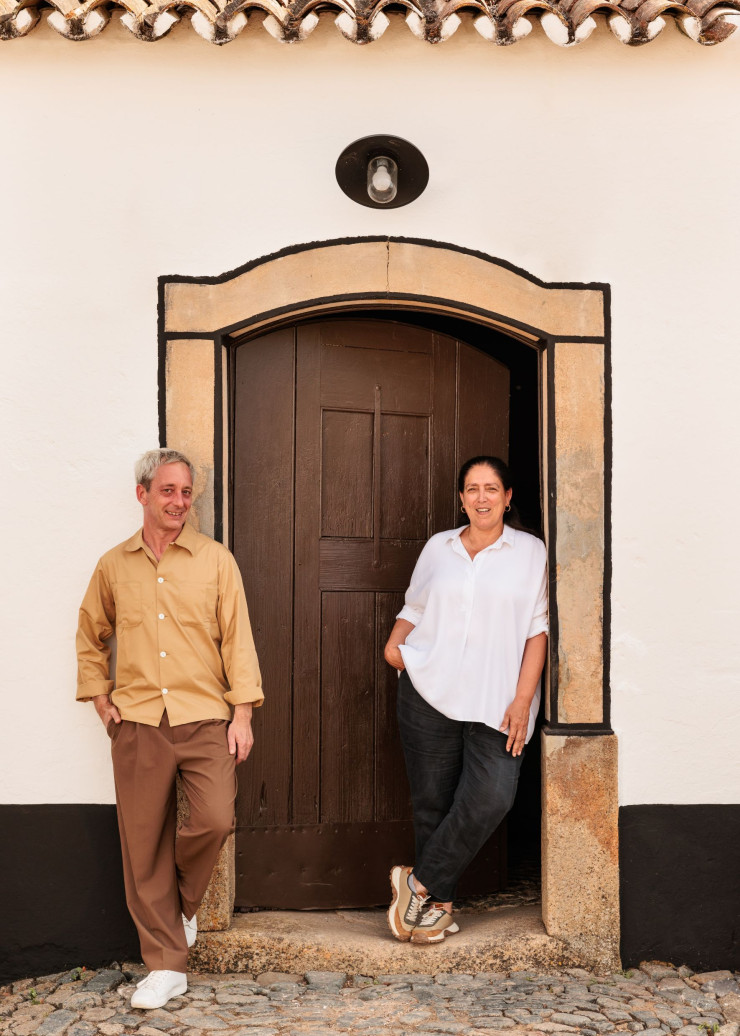 Le designer Sam Baron et la propriétaire Marta Menéres sur le seuil de la maison baptisée Val Guardes, du nom du lieu-dit.