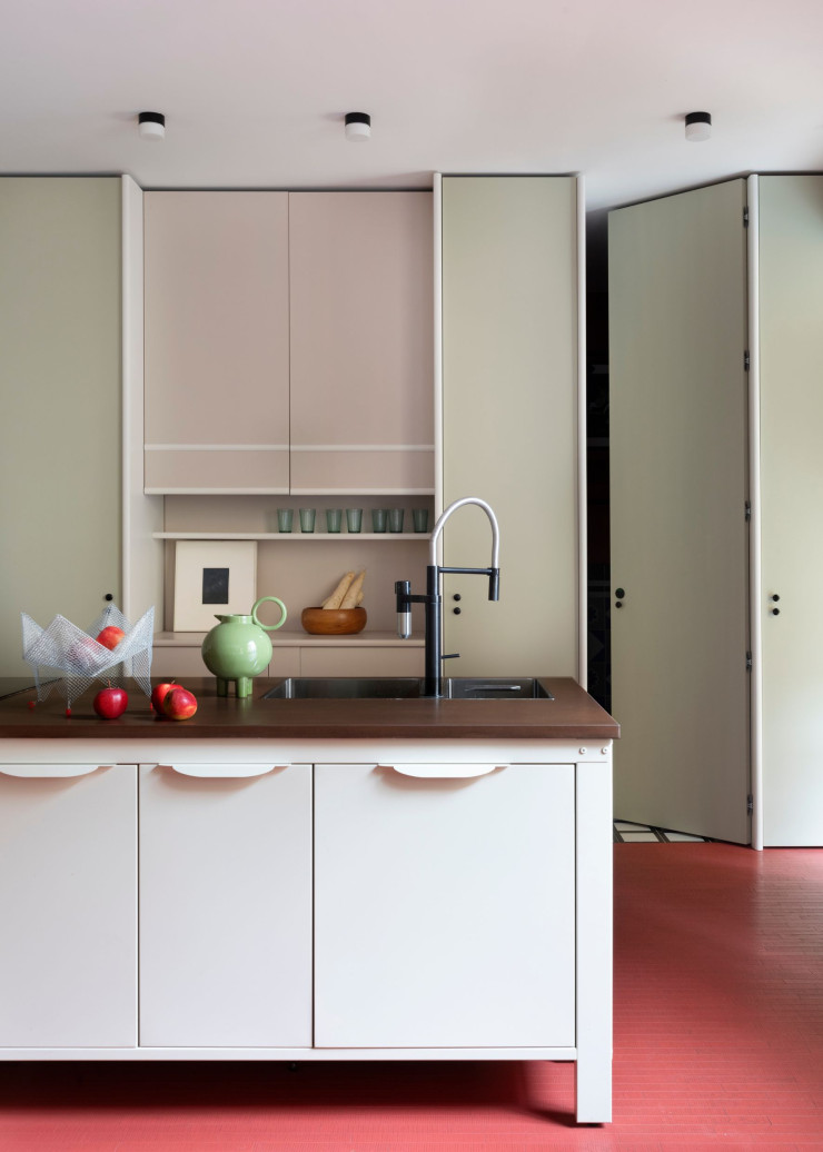 Côté cuisine, une niche de rangements traitée en résine Microresina (Kerakoll) interrompt le mur de façades. Sur l’îlot, coupe à fruits Otto+4coccodrilli, d’Elena Cutolo, et carafe Circle S, de Paolo Santangelo (Spazio Mari).