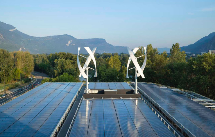 À Grenoble, le bâtiment Schneider Electric produit sa propre énergie, grâce à 4000 mètres carrés de panneaux photovoltaïques installés sur son toit et deux éoliennes verticales.