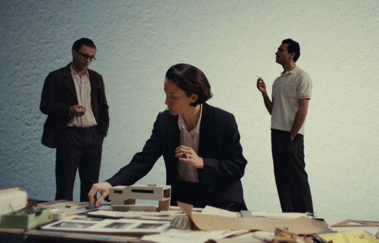 Extrait du film « E.1027, Eileen Gray et la maison en bord de mer », de Béatrice Minger et Christophe Schaub. Eileen Gray (Natalie Radmall-Quirke) en pleine réflexion, entouré du Corbusier à gauche (Charles Morillon) et de Jean Badovici à droite (Axel Moustache). © Roche Productions