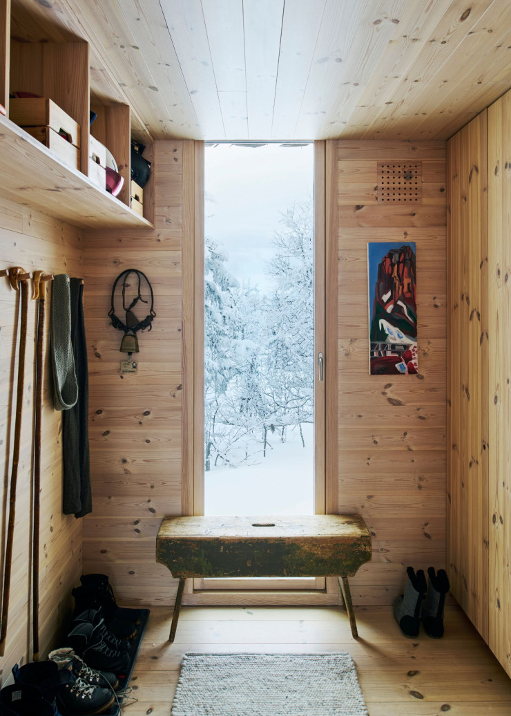 Ultra-fonctionnelle, la petite entrée offre un sas avec l’extérieur pour passer de la blondeur chaleureuse du pin au domaine neigeux. Banc chiné.